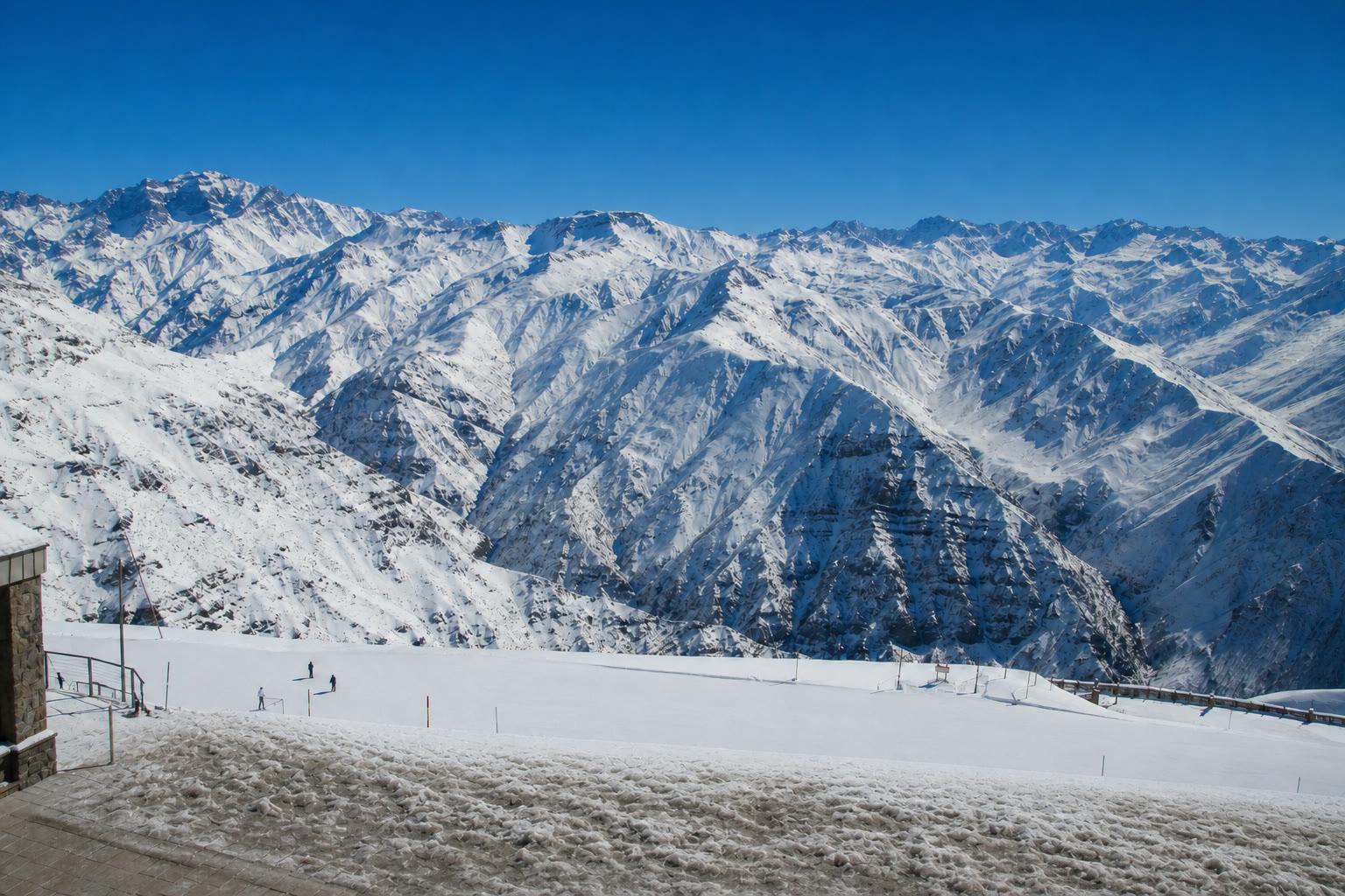 A mesma vista do Valle Nevado às 15h40: a base aparece pisoteada e achatada, e os vales da montanha ao fundo continuam exatamente igual de brancos.